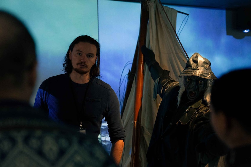 A person in a dark shirt standing next to a tent. 1