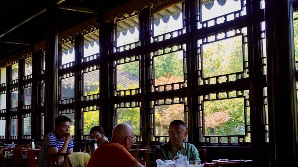 A traditional building with large windows and a view of trees. 2