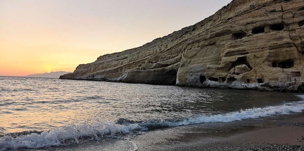 A coastal cliff with sea caves and a sunset over the ocean. 3
