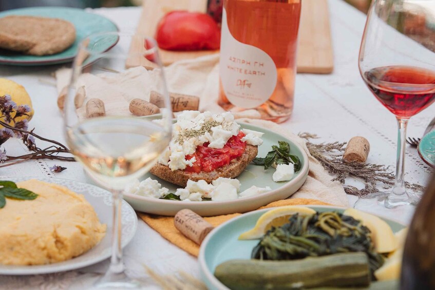 A table with food, wine glasses, and a bottle of white wine. 1