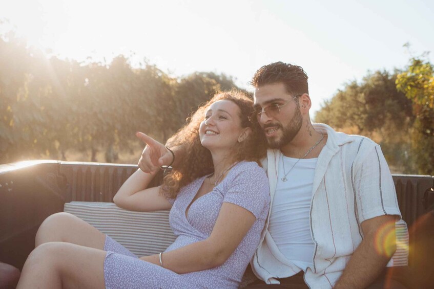 Two people sitting on a bench outdoors with trees in the background. 5