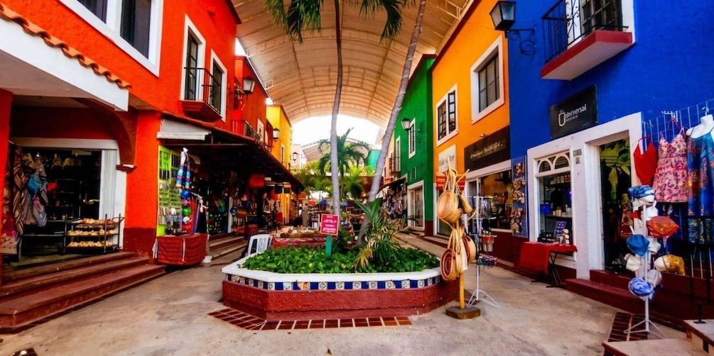 A colorful street with shops, a central planter, and a sign for Universal. 1