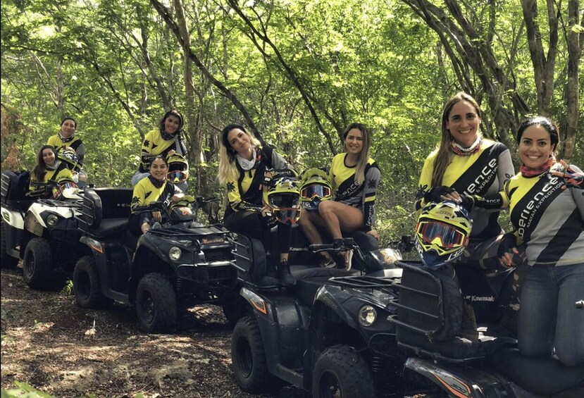A group of people on ATVs in a forested area. 5