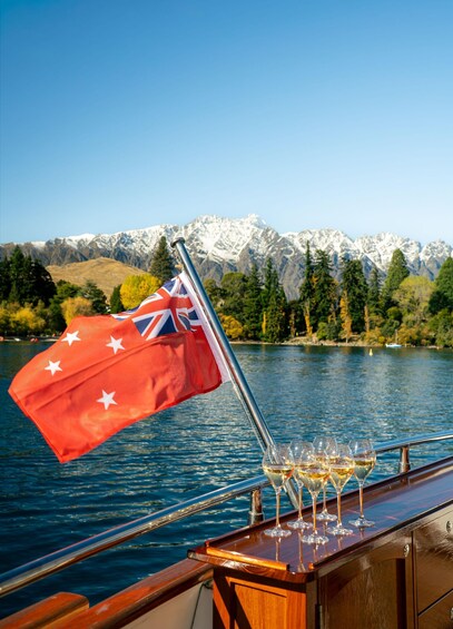 A flagpole with the Australian flag and a row of wine glasses on a boat deck. 3