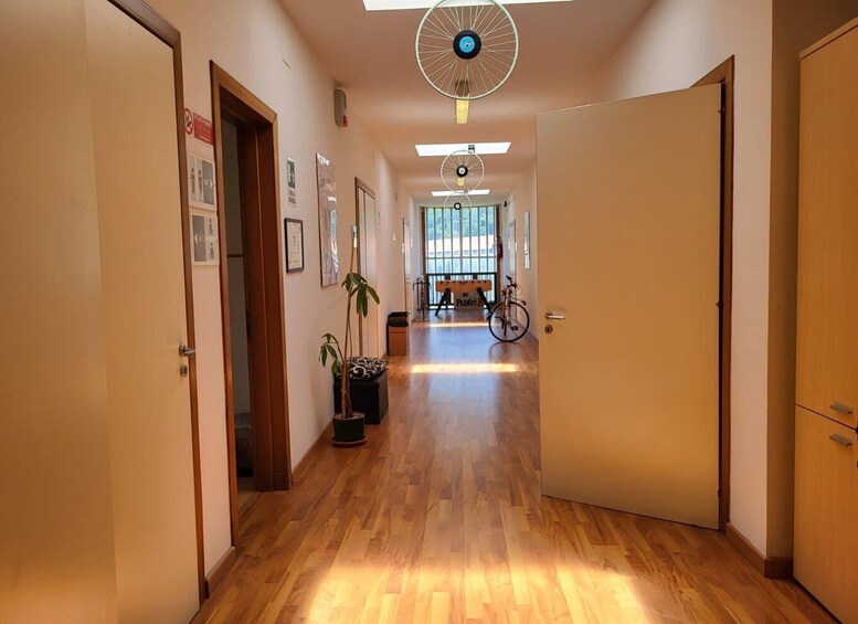 A hallway with wooden floors, a ceiling fan, and a bicycle. 1