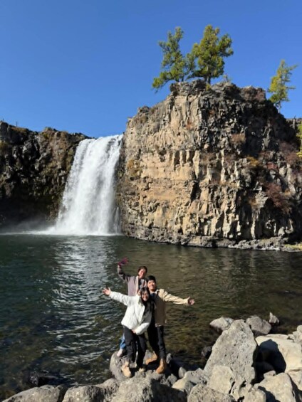 A waterfall, rocky terrain, and a clear blue sky. 2