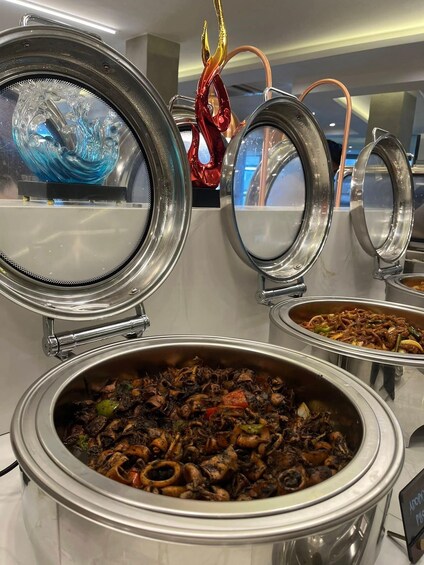A buffet with various dishes, including a large bowl of mushrooms and a dish with meat and vegetables. 4