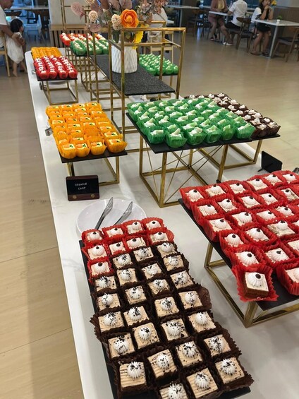 A bakery display with various cakes and pastries in different colors. 5