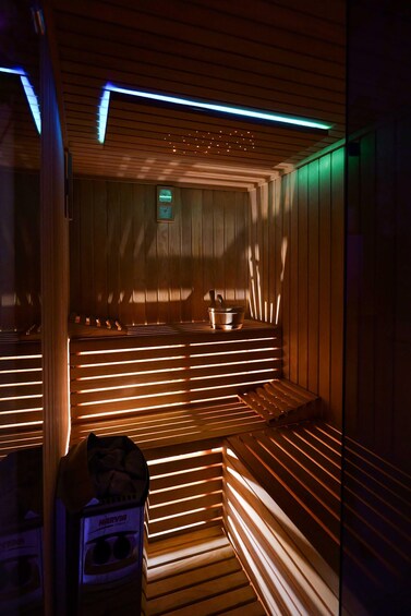 A sauna with wooden benches and a heater. 1