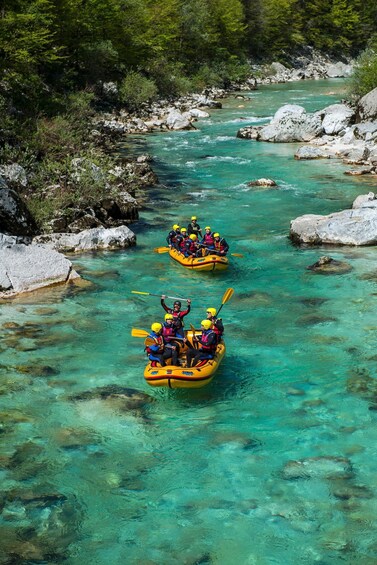 Two yellow kayaks on a clear turquoise river surrounded by rocks and greenery. 2