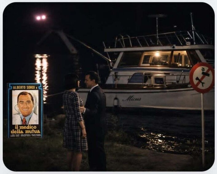 A nighttime scene with a boat named 'Micas' docked at a pier, a 'No Parking' sign, and a poster of 'Il medico della mutua' with a man and a woman standing nearby. 2