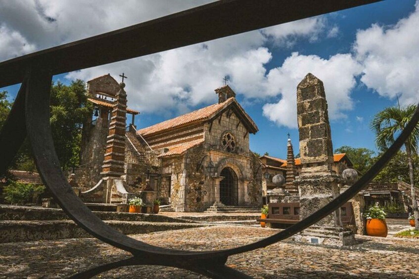 An ancient church with a bell tower and a tall monument. 1