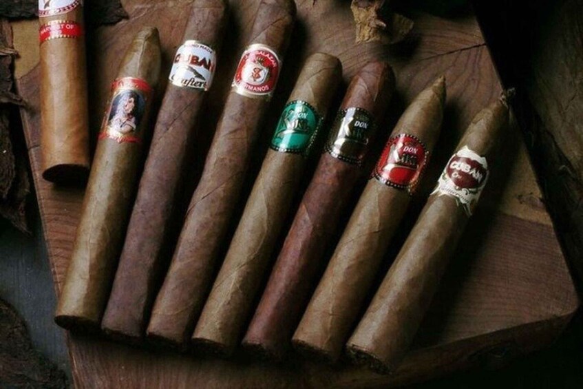 A wooden surface with cigars arranged in a row. 2
