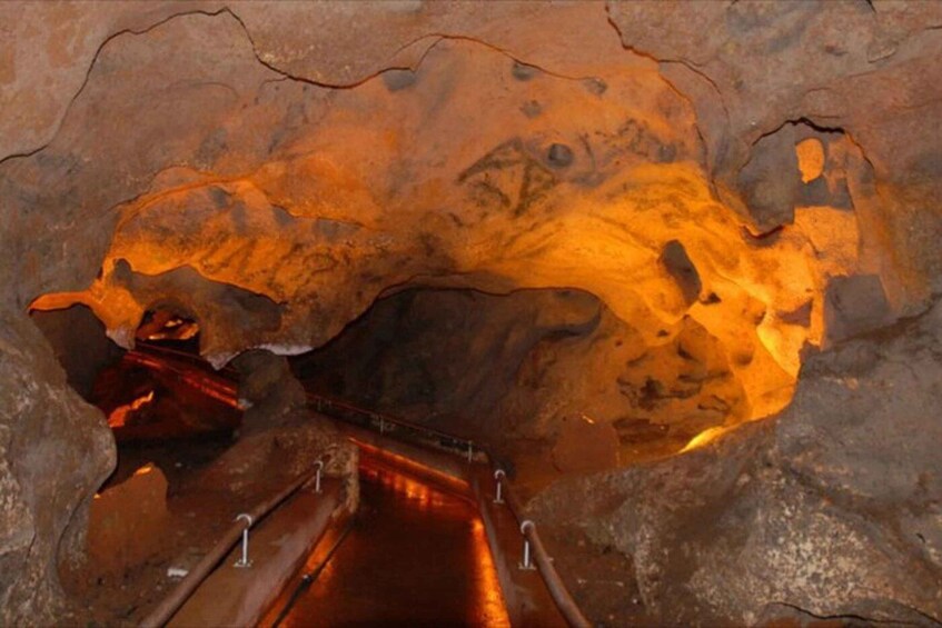A cave interior with a metal staircase leading down. 5