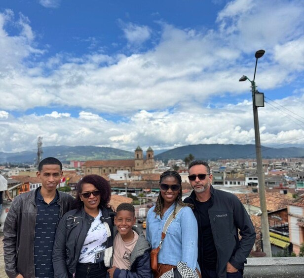 A group of people standing on a rooftop with a cityscape and mountains in the background. 5
