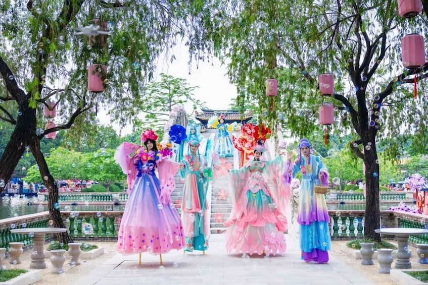 A traditional Chinese garden with ornate architecture, a water feature, and performers in colorful costumes. 4