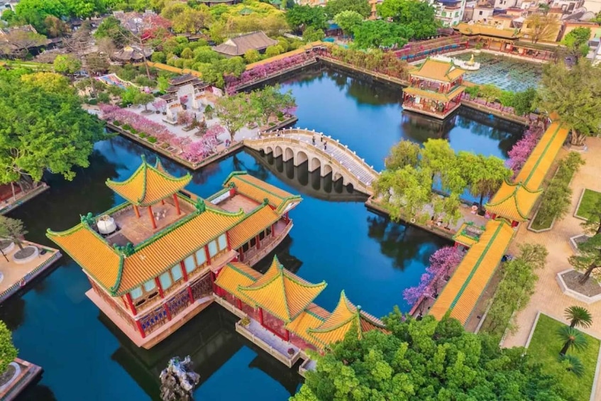 A traditional Chinese garden with a bridge, water features, and ornate buildings. 2