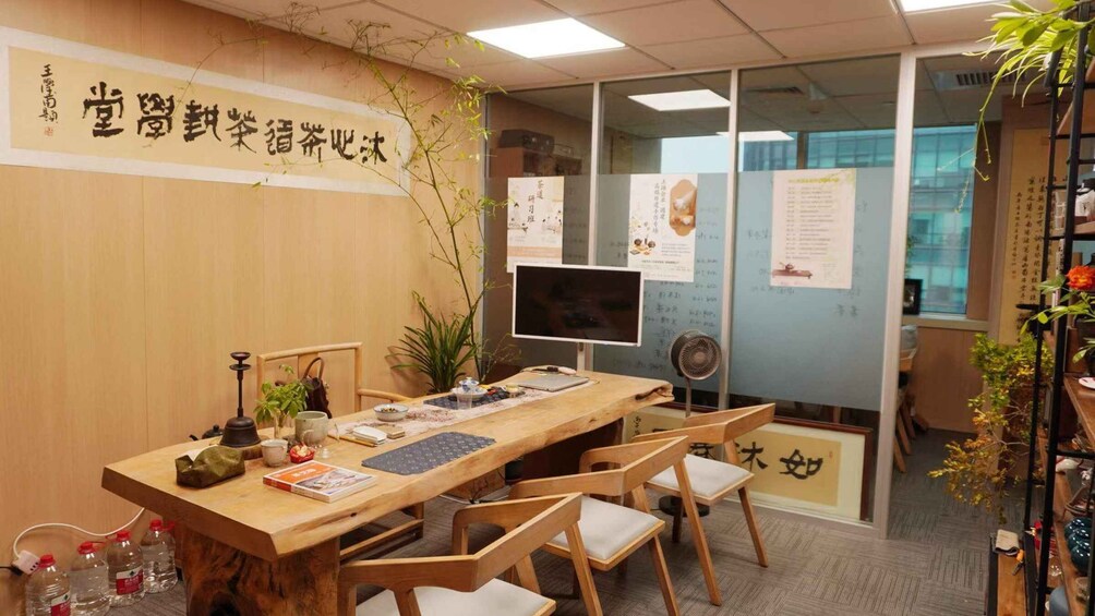 A wooden desk with a computer, books, and a plant. 3