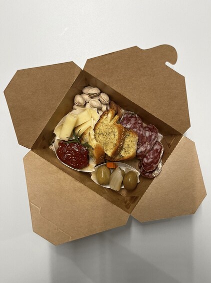 A box of assorted cheeses, olives, and bread. 5