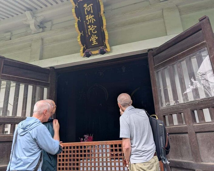 Two men standing at the entrance of a building with a sign above them. 4