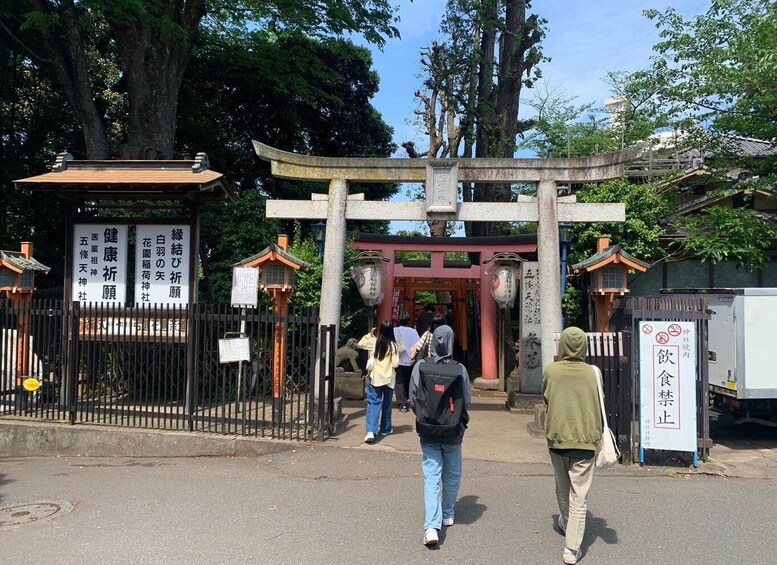 A traditional Japanese torii gate at a shrine entrance with visitors. 3