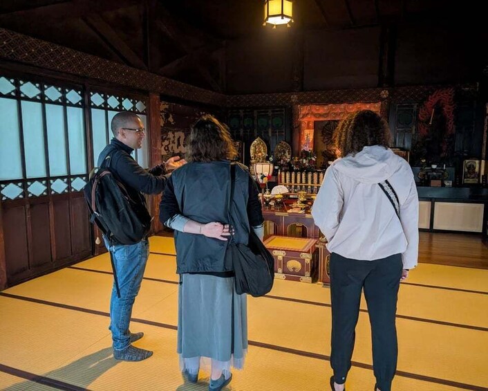 A traditional Japanese room with tatami flooring, a shoji screen, and a tea ceremony setup. 5