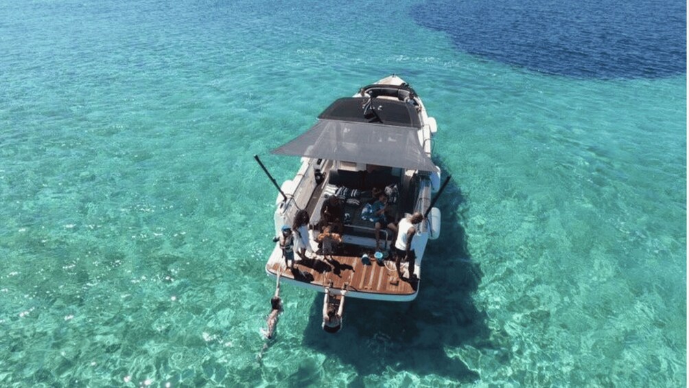 A boat anchored in clear turquoise water. 1