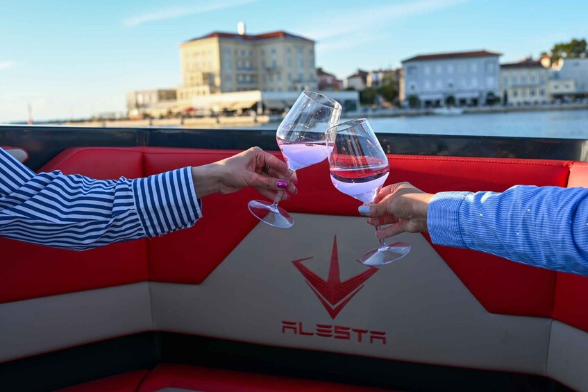 Two people toasting with wine glasses on a boat with a cityscape in the background. 4