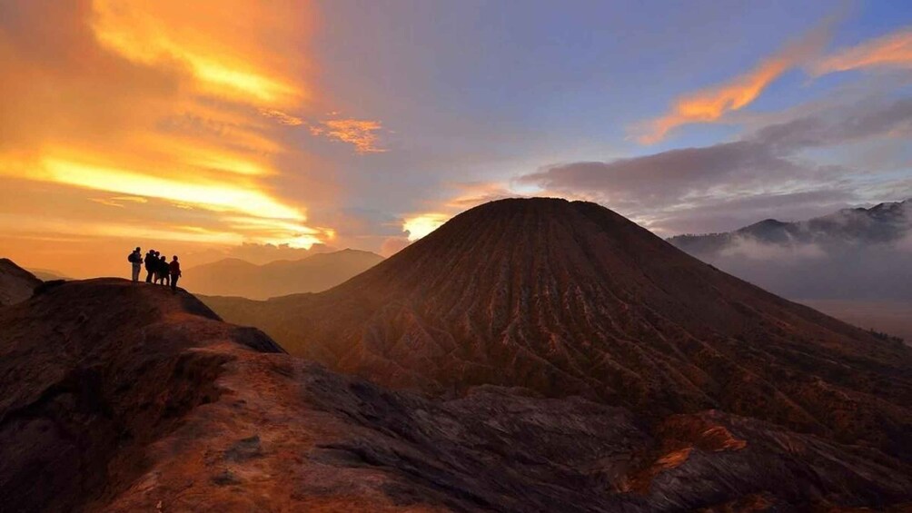 A group of people on a mountain ridge during sunset. 1