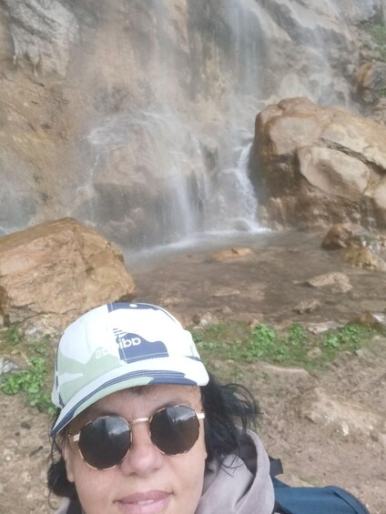 A person with a backpack near a waterfall. 1