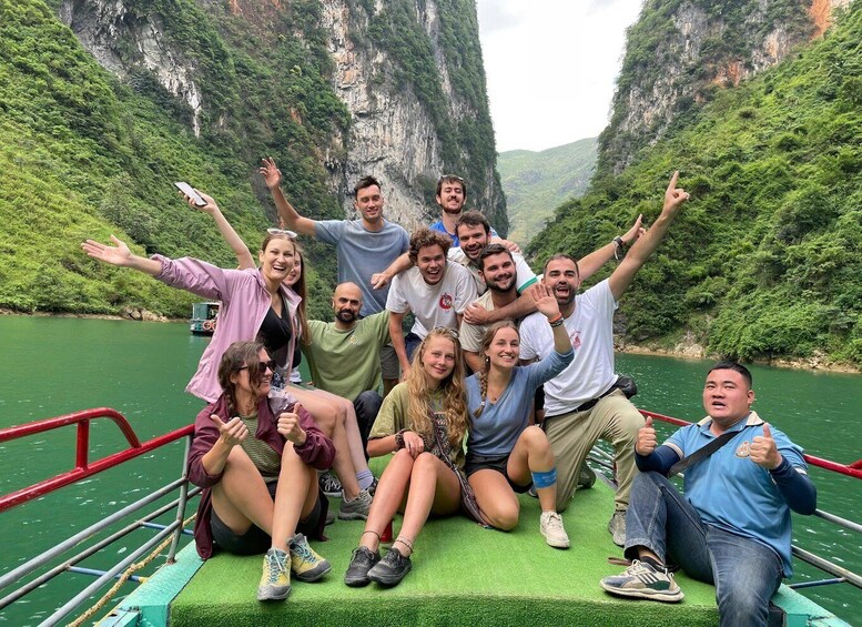 A group of people on a boat with a mountainous landscape in the background. 2