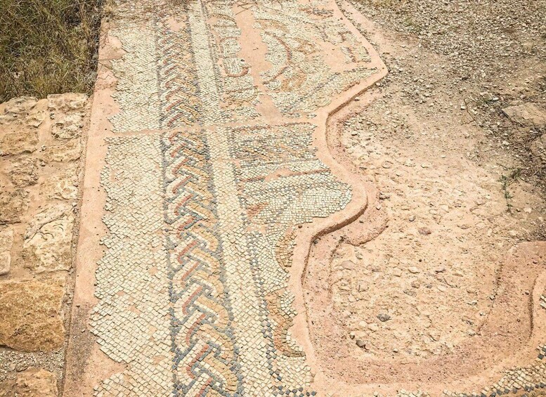 A mosaic with geometric patterns and a wavy line design. 4