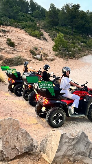 Four ATVs parked on a dirt path with a rocky hillside in the background. 3