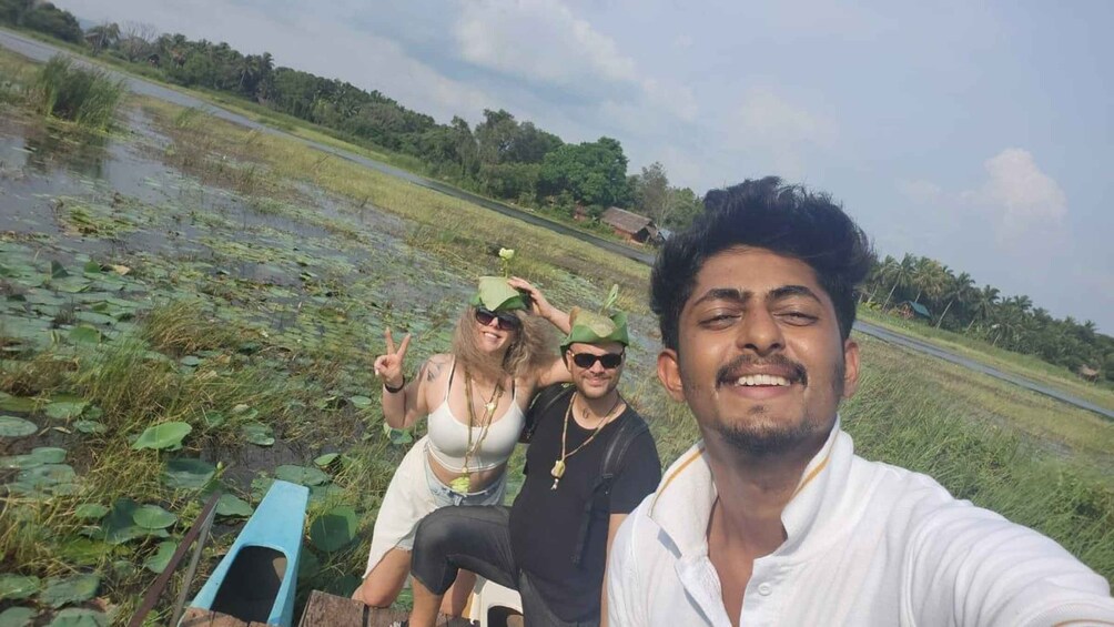 A group of people in a natural setting with a water body and greenery. 1