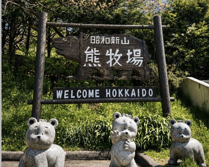 A wooden sign with Japanese characters and 'WELCOME HOKKAIDO' written below. 4