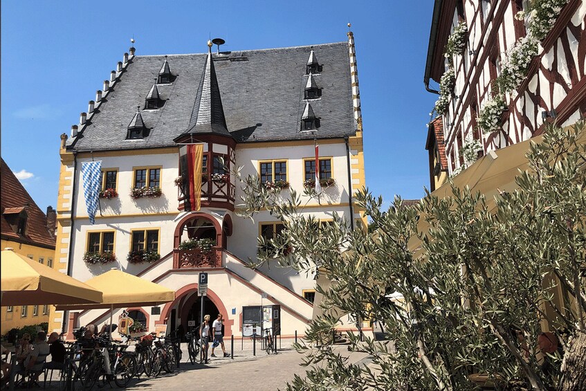 A traditional European building with a steeply pitched roof, dormer windows, and a central tower. 3