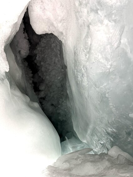 An ice cave with a narrow passage and a large ice formation on the right. 1