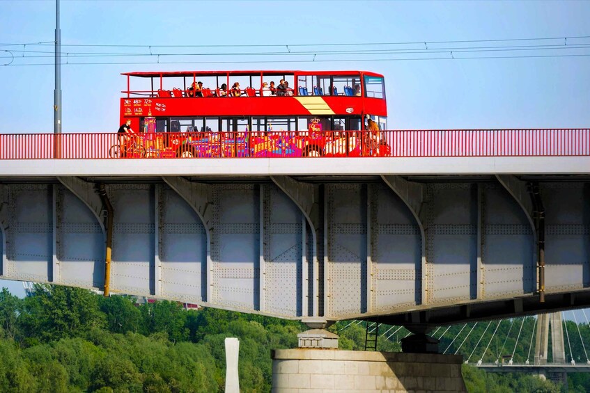 A red double-decker bus traveling on a bridge. 5