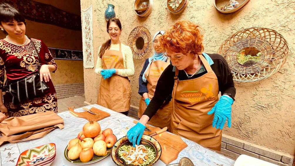 A person preparing food with vegetables and a bowl on a table. 2