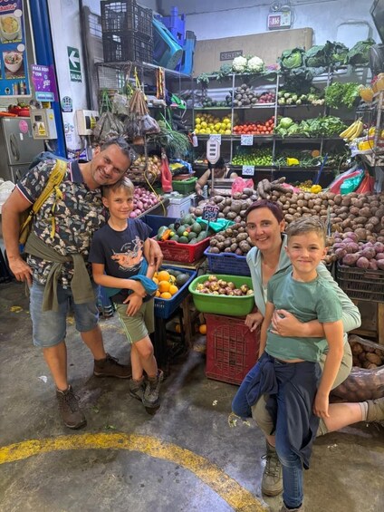 A family at a market stall with fresh produce and price tags. 3