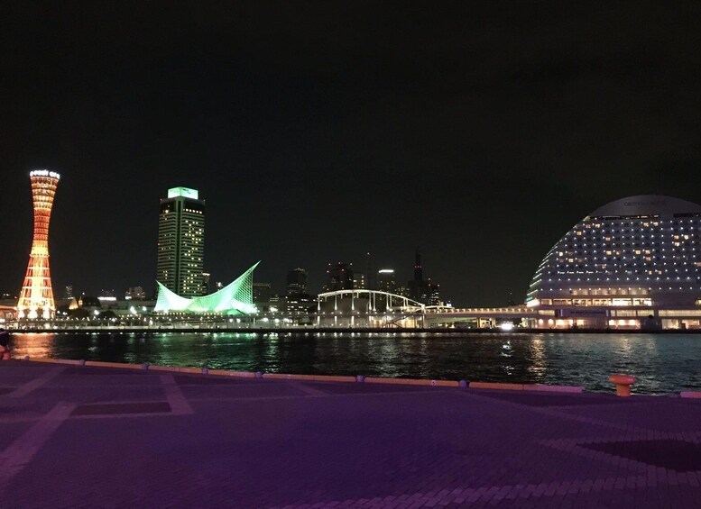 A cityscape at night with illuminated buildings, a bridge, and a waterfront. 1