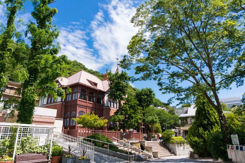A red brick building with a steep staircase, surrounded by lush greenery and a clear blue sky. 4