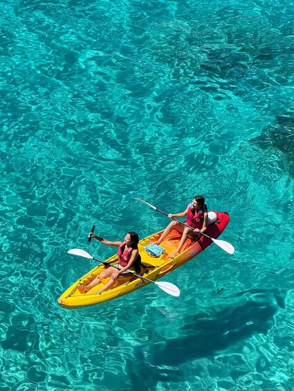 Two people kayaking in a clear blue pool. 4