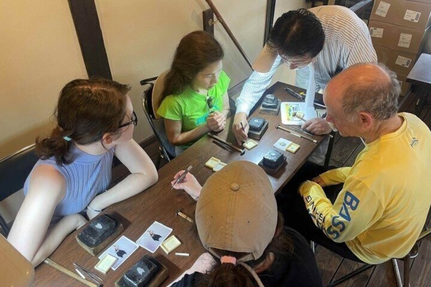 A group of people sitting around a table with various items like cards and a hat. 3
