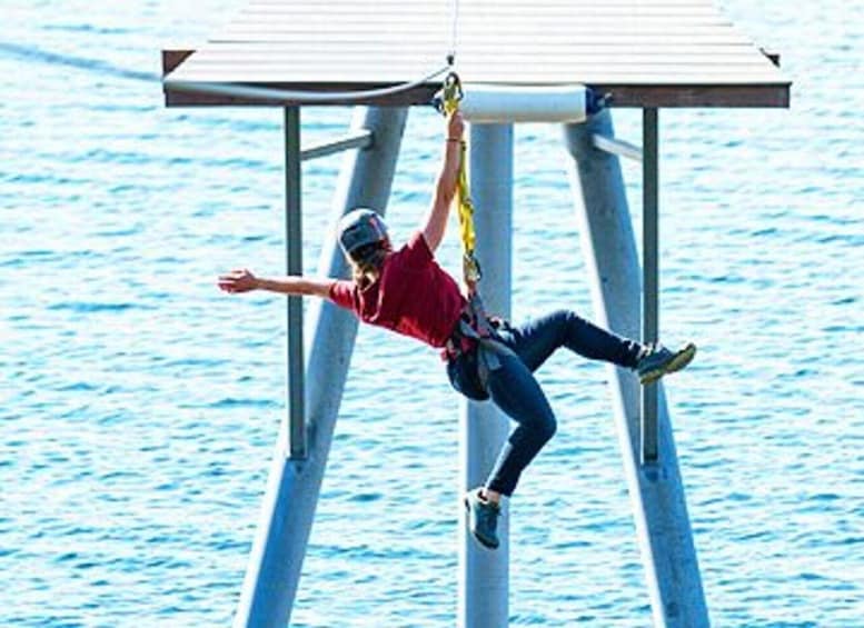 A person bungee jumping from a high structure over water. 3