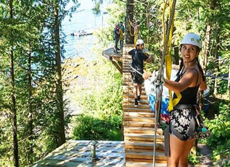 A person on a zip line course surrounded by trees. 4