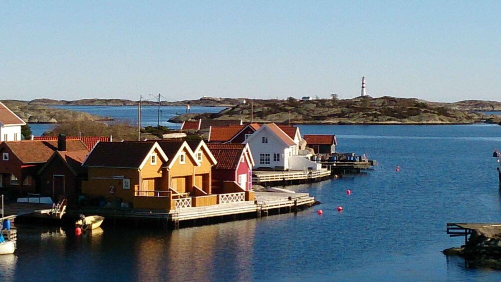 A coastal village with colorful houses, a pier, and a lighthouse in the distance. 4