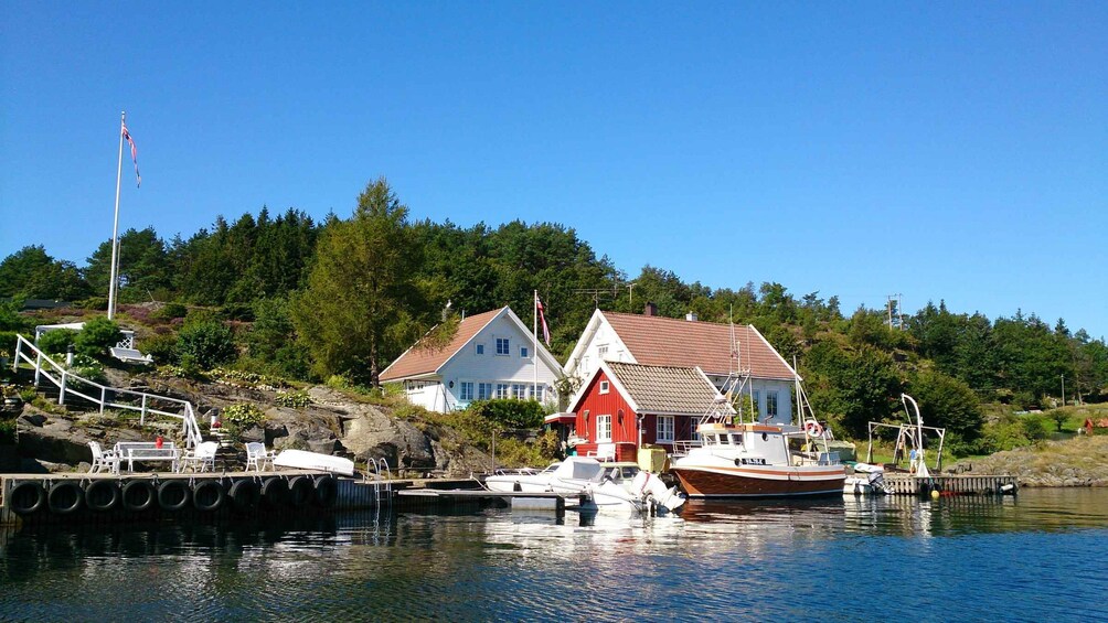 A harbor with boats, a red house, and a flag. 3