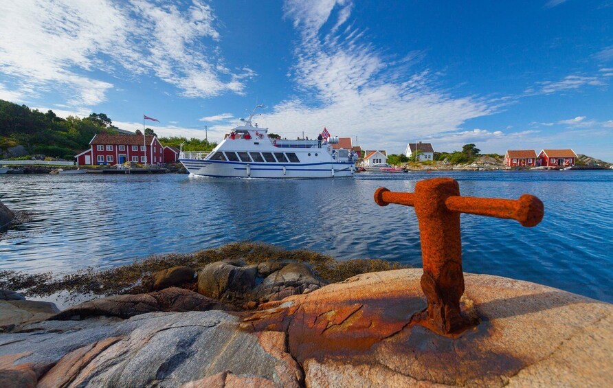 A boat on a calm water body, a red building, and a rusted metal structure. 2