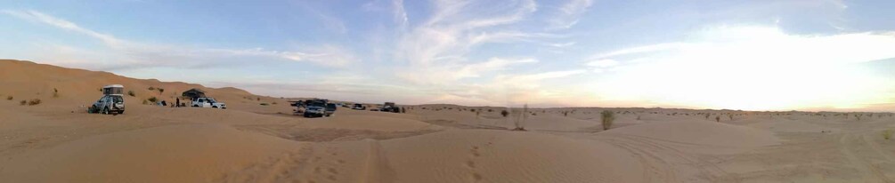 A desert landscape with sand dunes and vehicles. 3